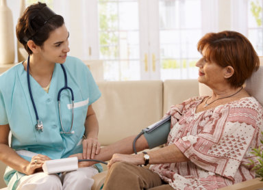 Nurse measuring blood pressure of senior women at home
