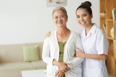 young nurse and senior woman looking at camera with smiles