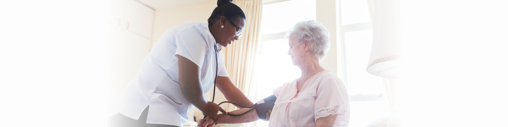 Female nurse doing blood pressure measurement of a senior women patient